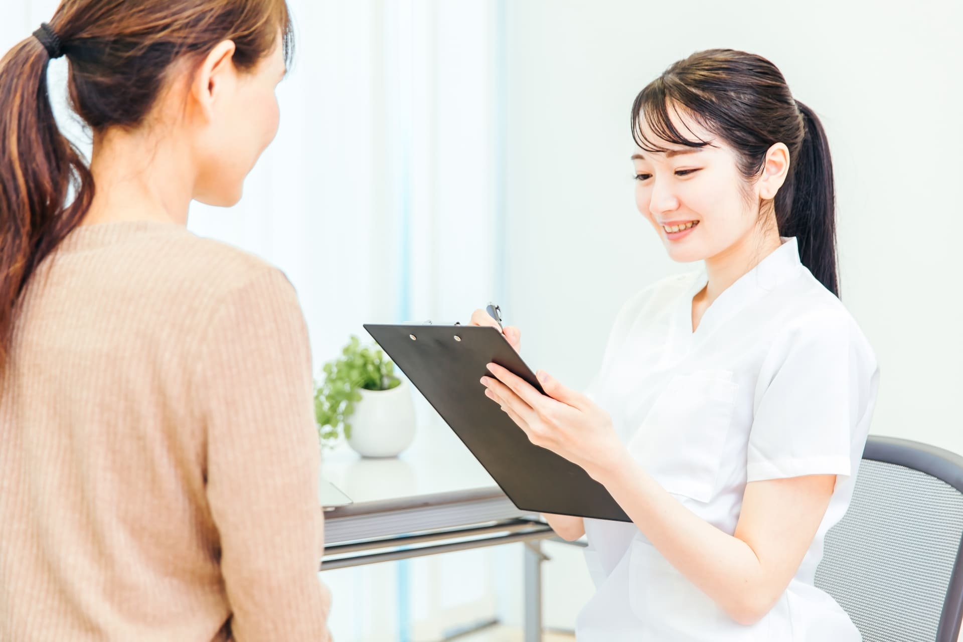 利用者さんの話を聞きながら症状を確認する看護師